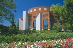 Theatre on sunny day with blue sky and flowers out front. 