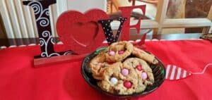 Chocolate chip cookies with pink M&Ms with love sign in the background.