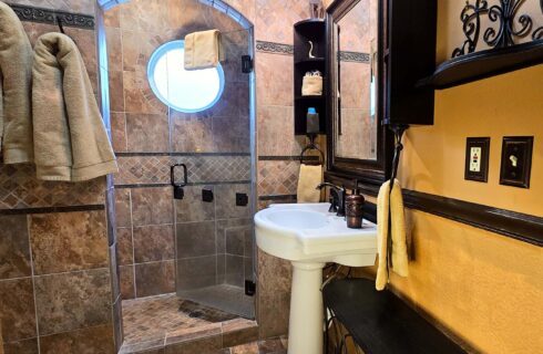 Bathroom with tiled arch, towels, and sink