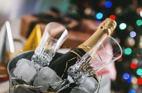 two champagne glasses with ice bucket and champagne